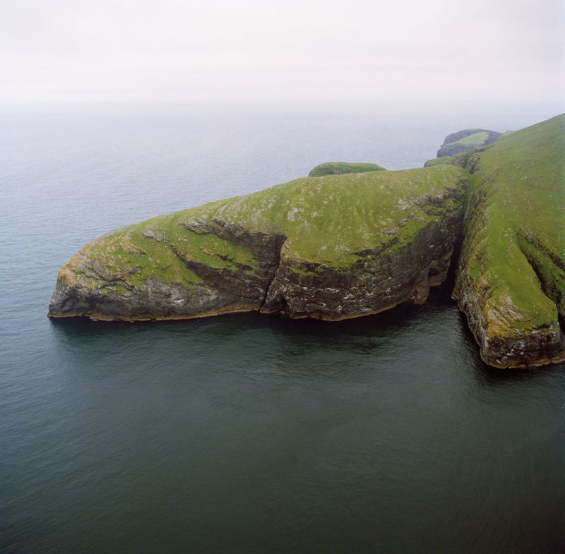  Dùn Mingulay, Western Isles. Seen here from the south, this exposed promontory jutting out 600m into the Atlantic drops sheer to the sea along its northern flank (Crown © RCAHMS SC906354).
