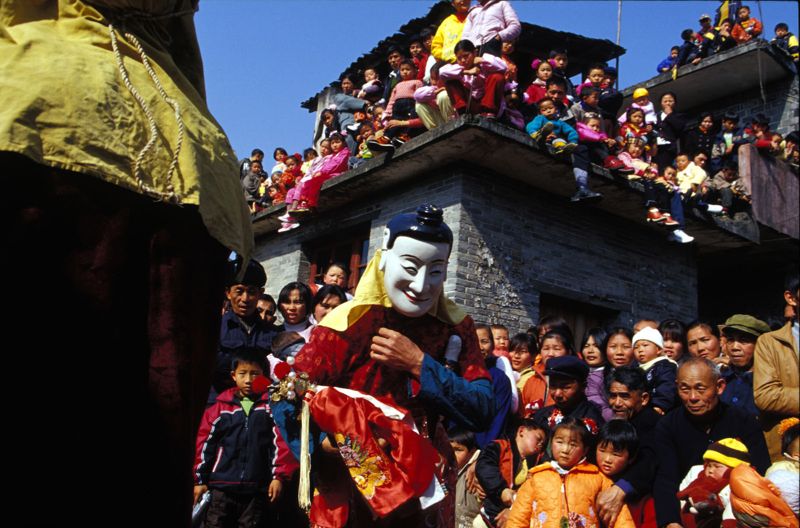 Grand-mère nuo tenant le garçonnet nuo, 1er de l’an, 2002 
(photo © Zeng Nian 曾年).
