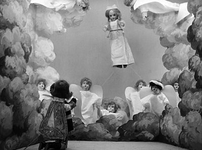Marguerite est suspendue dans les airs, regardant vers le bas où des anges se rassemblent.