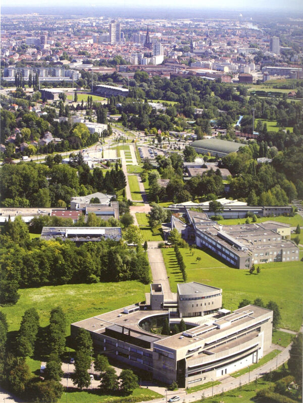 Fig. 14. Photographie aérienne du campus de l’Illberg. Le mail central offre une perspective vers le cœur historique de Mulhouse, notamment marqué par la Tour de l’Europe (cliché Norbert L’Hostis, ville de Mulhouse, s.d. [vers 2000]).